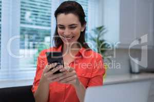 Woman using mobile phone at home