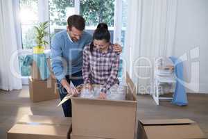 Couple unpacking boxes in new home