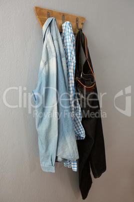 Jeans, denim jacket and shirt hanging on hook