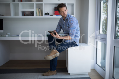 Thoughtful man using digital tablet