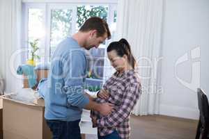 Man touching womans pregnant belly at new house