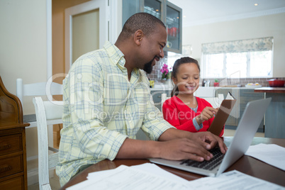 Daughter showing diary to father in kitchen