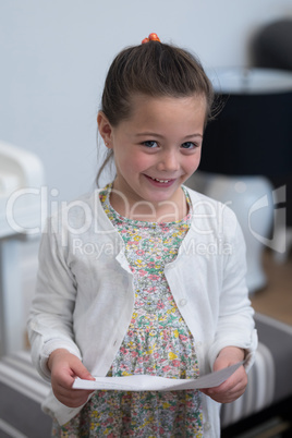 Portrait of cute girl standing with musical sheet