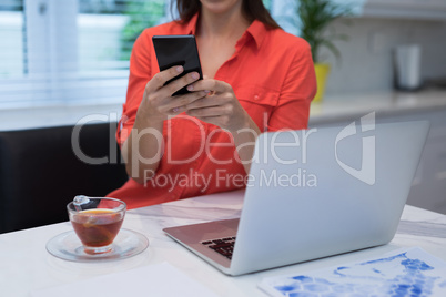 Woman using mobile phone at home