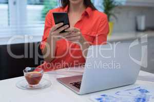 Woman using mobile phone at home