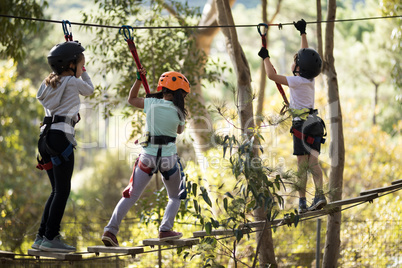 Determined kids crossing zip line