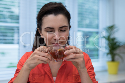 Woman having lemon tea in kitchen