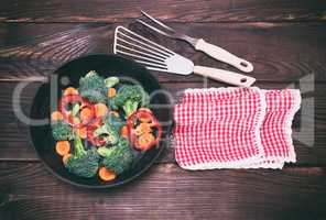 cast-iron frying pan with pieces of carrots, broccoli