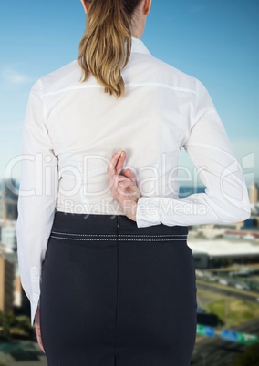 Businesswoman crossing fingers in city