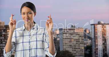 Businesswoman crossing fingers in city