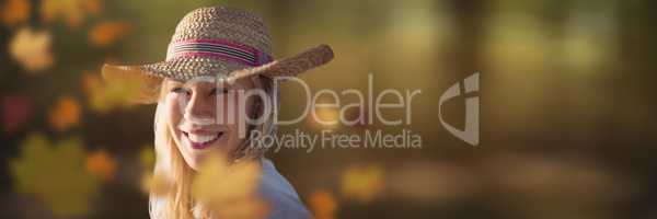 Woman wearing hat in forest with leaves