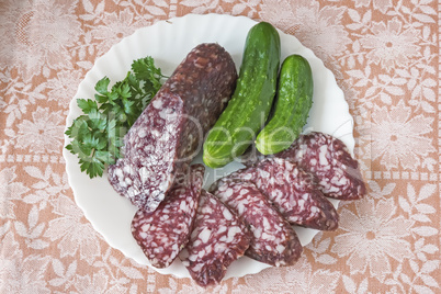 Slices of sausage and cucumber on the plate.