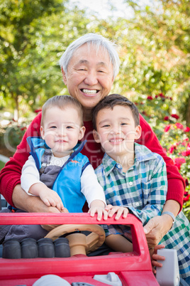 Happy Senior Adult Chinese Man Playing with His Mixed Race Grand