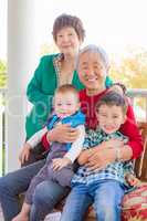 Senior Adult Chinese Couple Sitting With Their Mixed Race Grandc