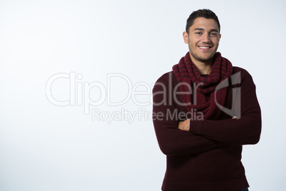 Smiling man standing with arms crossed against white background