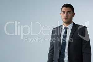 Confident businessman standing against white background