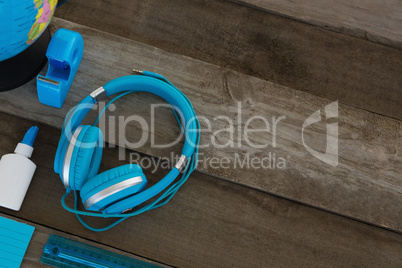 Headphone with other stationery on wooden table