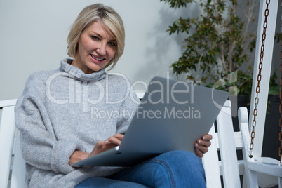 Beautiful woman using laptop in porch