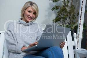 Beautiful woman using laptop in porch