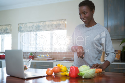 Beautiful woman learning food recipe from laptop