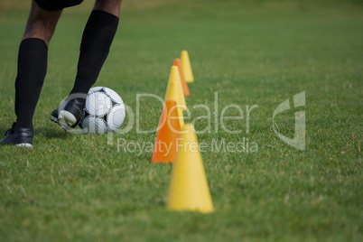 Soccer player dribbling through cones