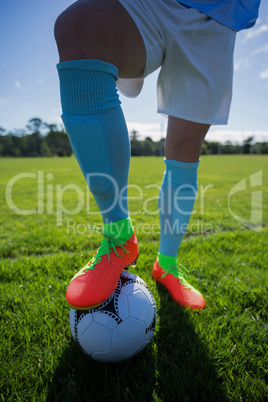 Football player standing with soccer in the ground