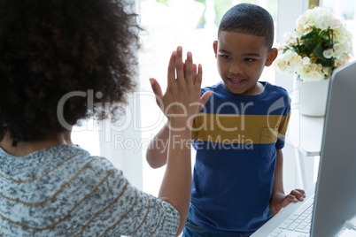 Mother giving high five to his son