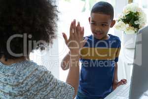 Mother giving high five to his son