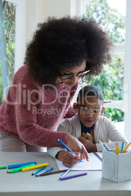 Mother helping her son in doing homework