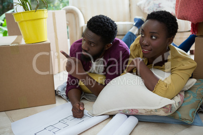 Couple discussing over blueprint