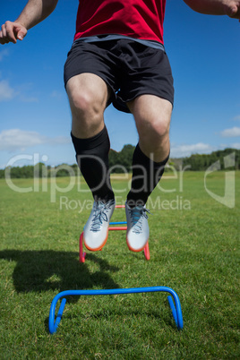 Soccer player practicing on obstacle