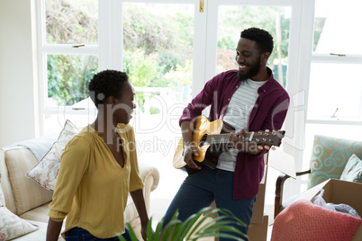 Man playing guitar for woman