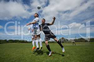 Football players playing soccer in the ground