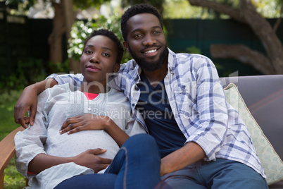 Couple sitting together on sofa in garden