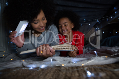 Mother and daughter reading a book at home