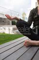 Mid section of woman practicing yoga in porch