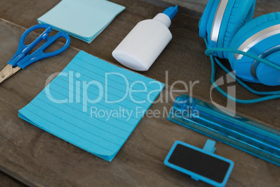 Headphone and various stationery on wooden surface