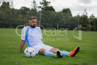 Football player relaxing in the ground