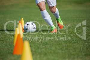 Soccer player dribbling through cones