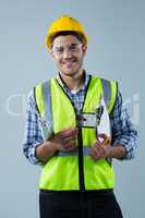 Male architect holding clipboard and blueprint against white background