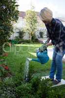 Woman watering plants in garden