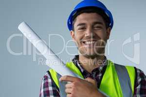 Male architect holding blueprint against white background