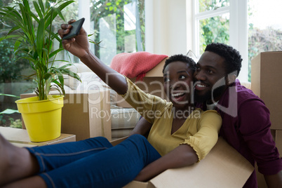 Couple taking selfie with mobile phone in their new house