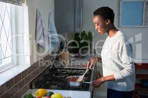 Beautiful woman cooking food in kitchen