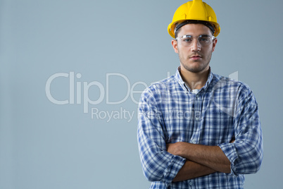 Male architect standing with arms crossed against white background
