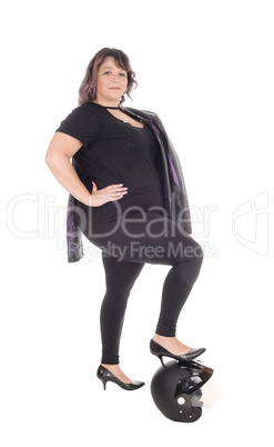 Full size woman standing with leg on helmet