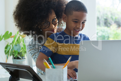 Mother and son using laptop