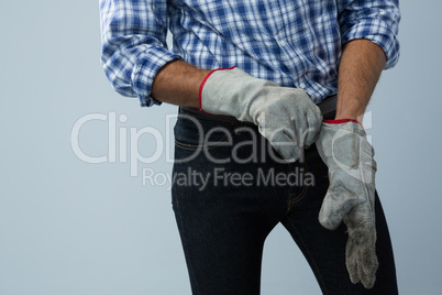 Male architect wearing gloves against white background