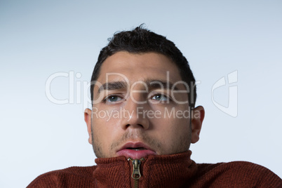 Scared man standing against white background