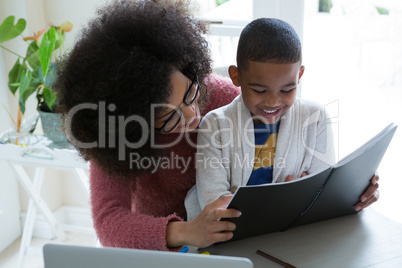 Mother helping her son in his studies